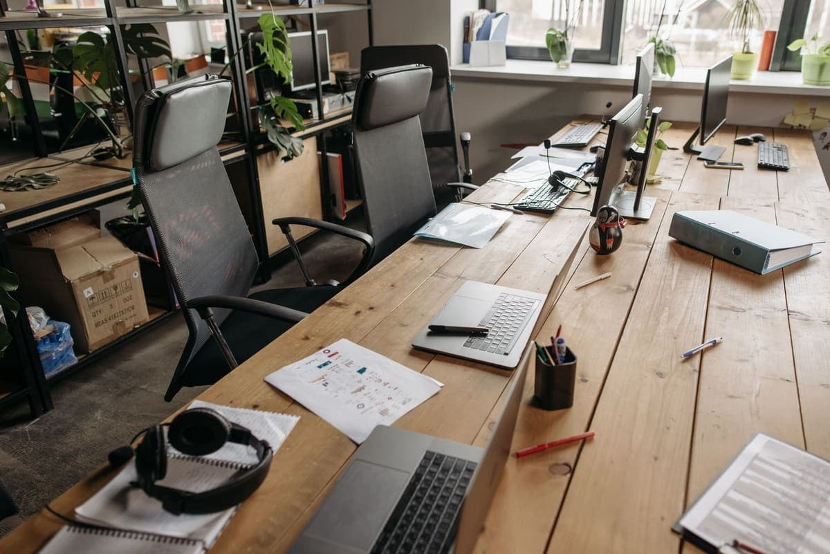 Grand espace de bureaux avec longues tables et postes de travail